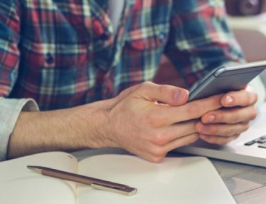 Man at desk using cell phone