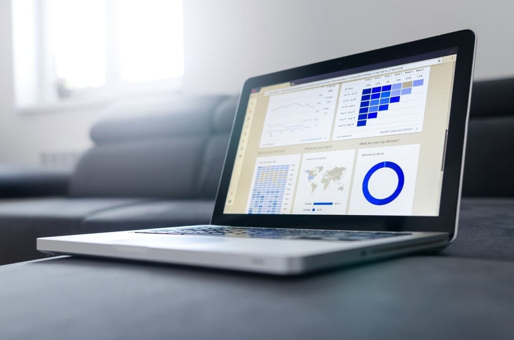 Laptop on a desk displaying website analytics data and traffic graphs.