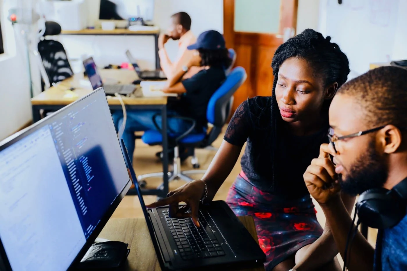 Two college students studying together at a laptop on an education website.