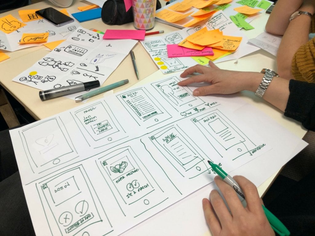 Designer wireframing a website navigation menu on paper
