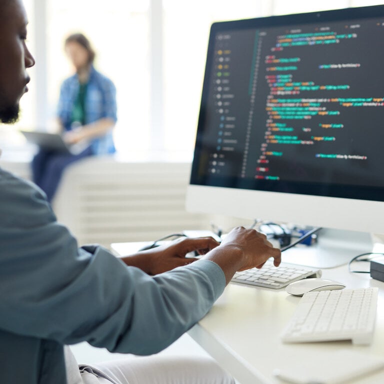 Developer writing website code on a desktop monitor