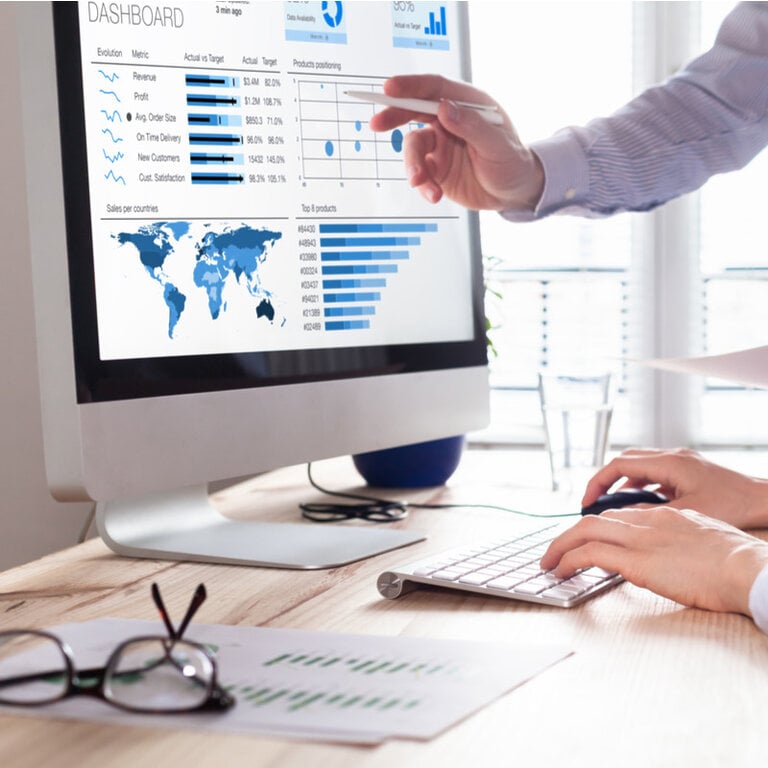 Analytics dashboard with revenue metrics and world sales map on a monitor