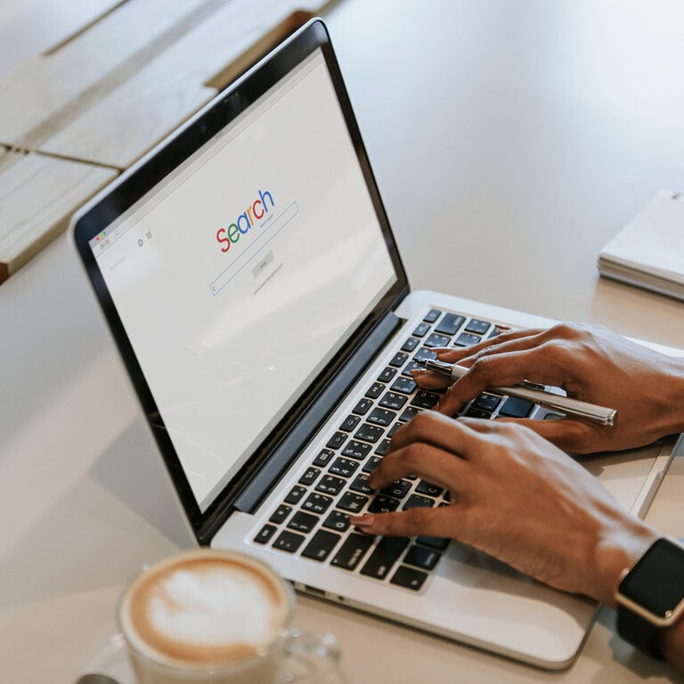 Person searching on a laptop with a search engine homepage open