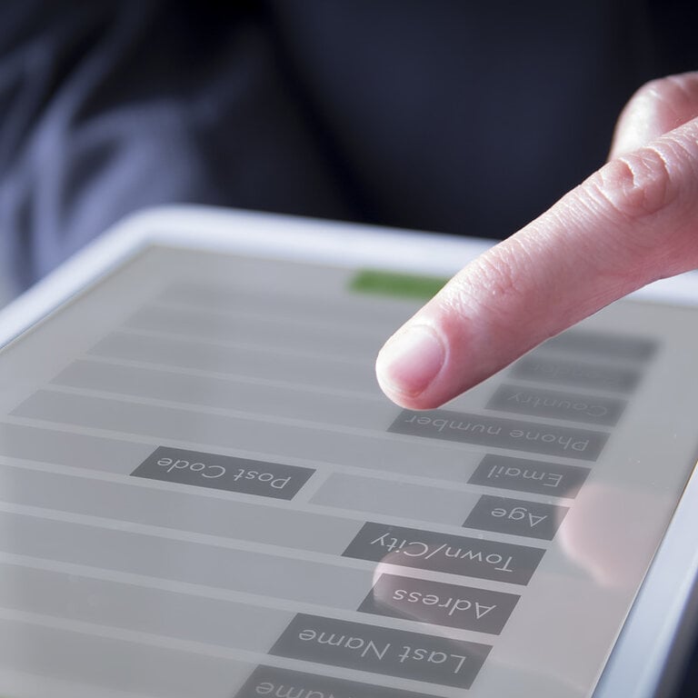 Finger tapping a tablet lead-capture form with contact fields