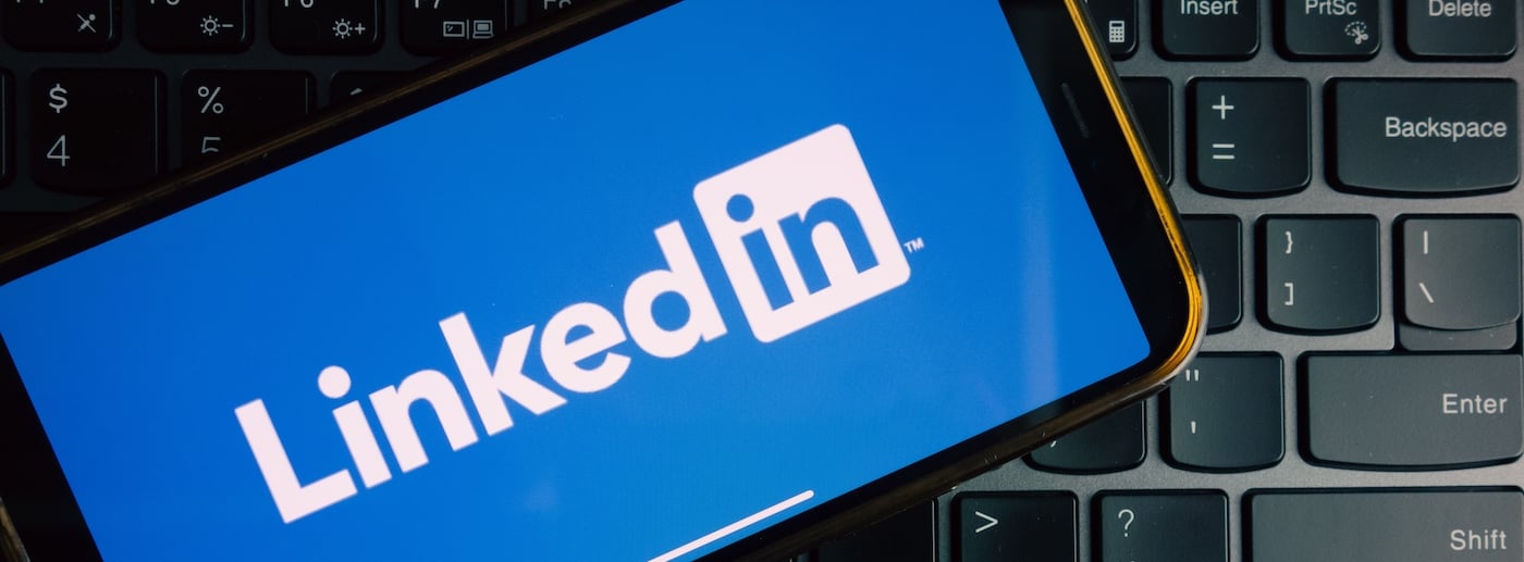 LinkedIn advertising concept for manufacturers showing B2B ad targeting on a factory floor.