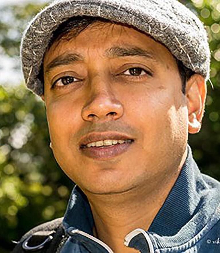 Headshot of Viki wearing a flat cap outdoors