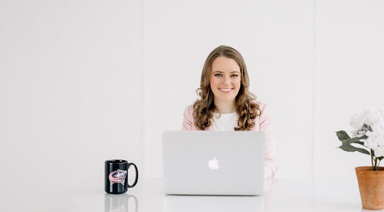 Clare Lewis working at her desk with a coffee mug at 3 Media Web.