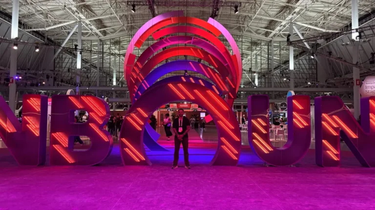 Adrian standing in front of the illuminated UNBOUND sign in a large convention hall