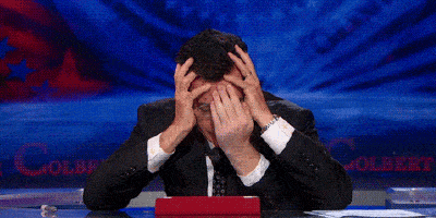 Stephen Colbert covering his face GIF