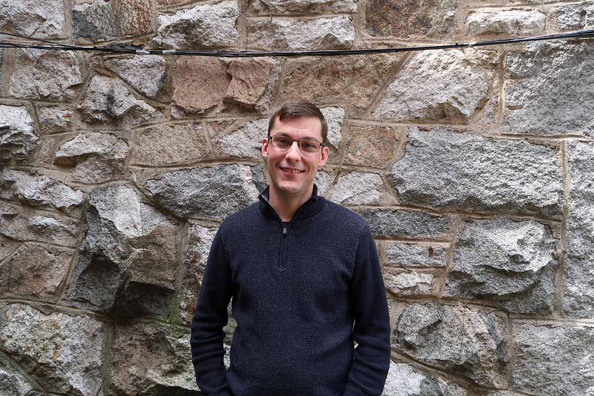 Mike St. Jean standing in front of a rock wall