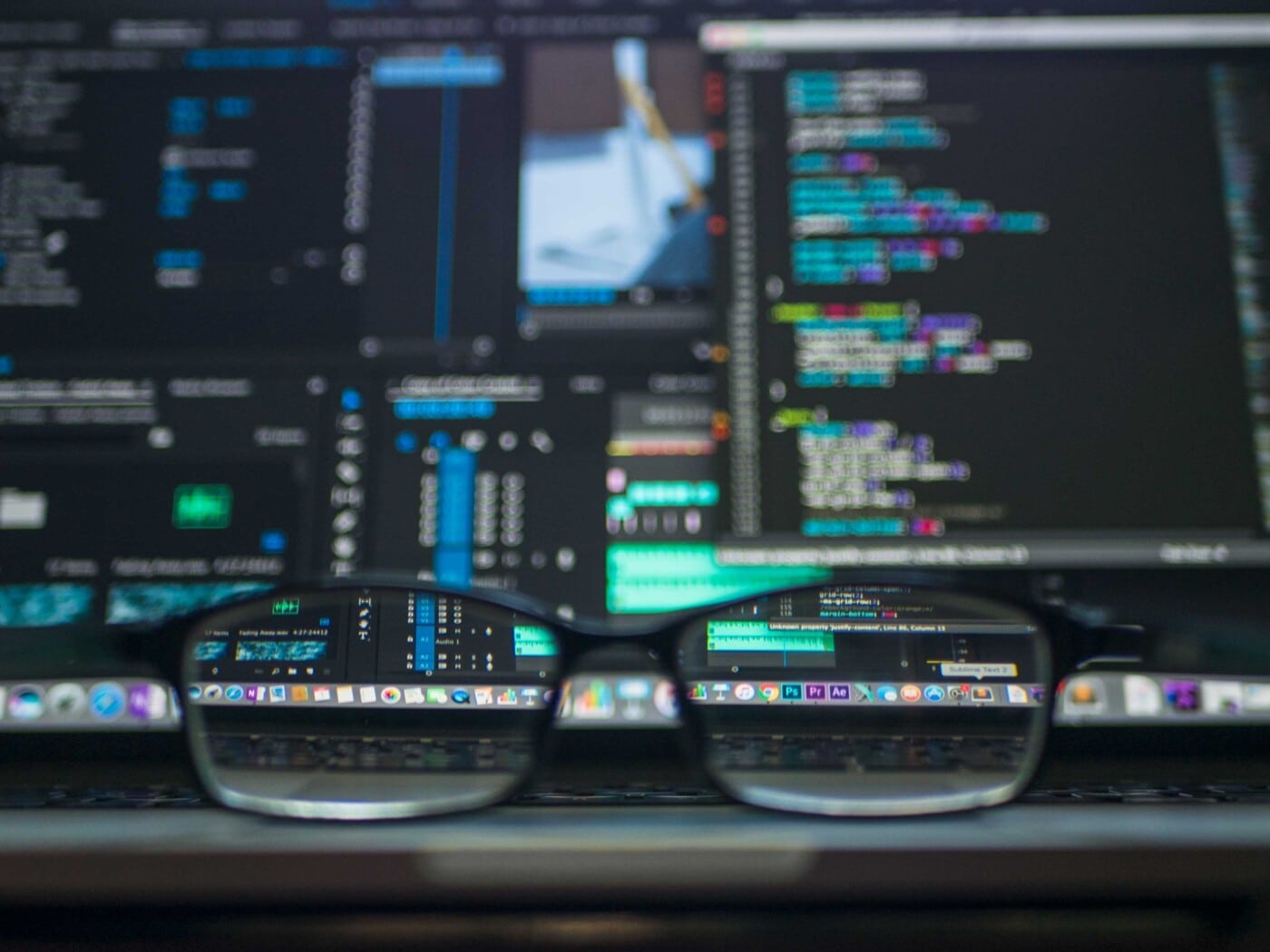 glasses sitting in front of computer monitors with code