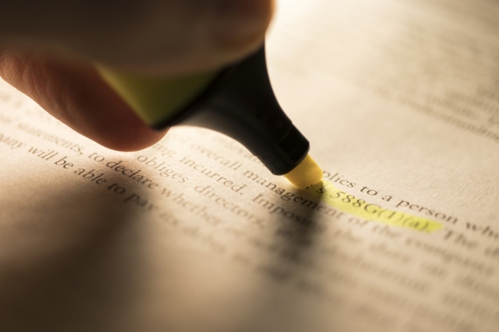 person using highlighter to highlight portion of legislation