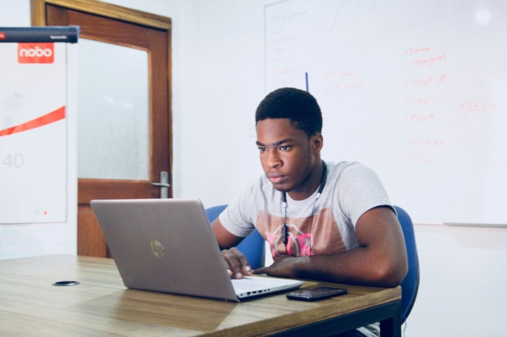 teenager using laptop computer in classroom setting