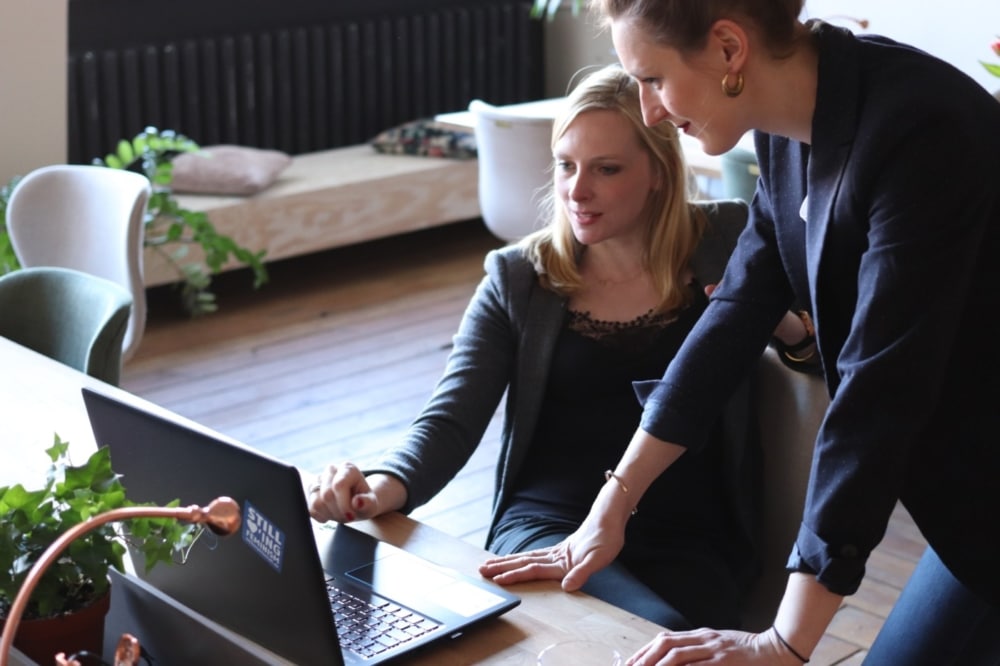 two businesswomen discussing a website redesign